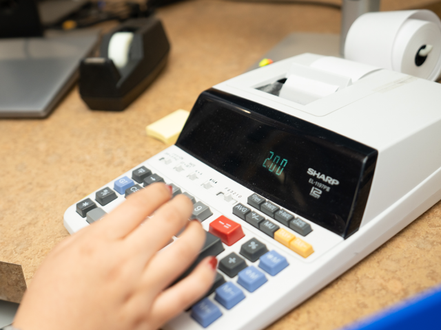 Hand typing on calculator